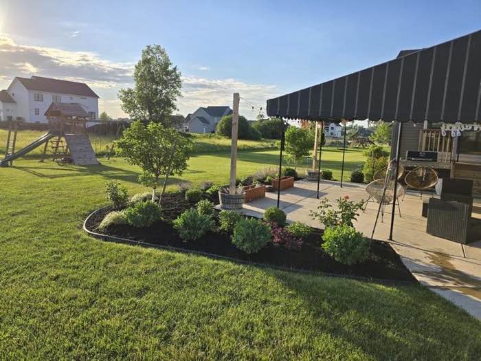 Backyard patio beds planted and mulched at golden hour