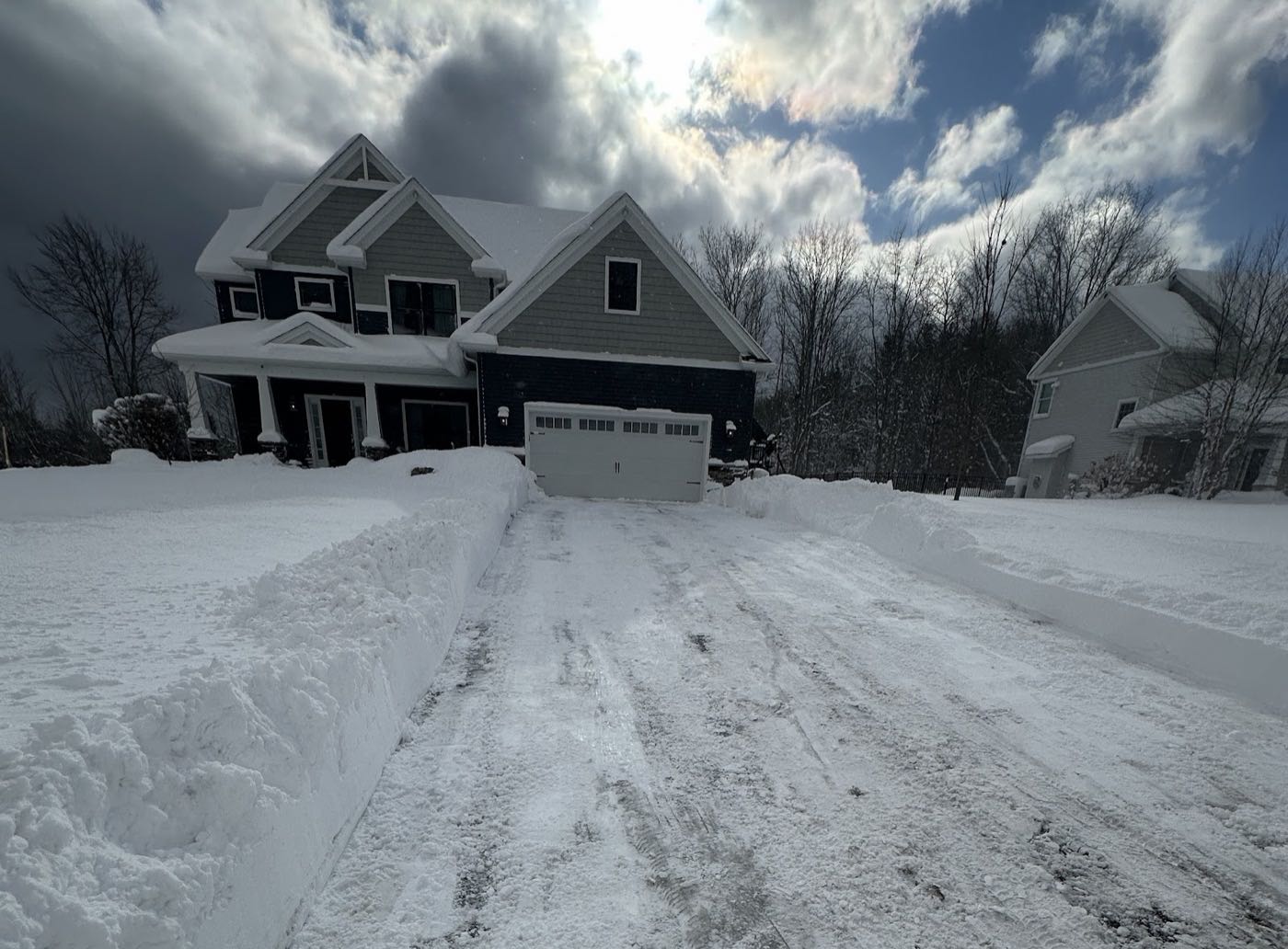 Residential driveway plowed clean with tall snow banks